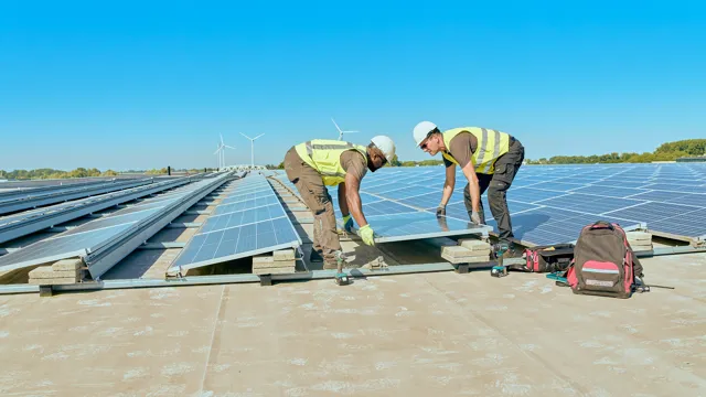Zonnepanelen op dak plaatsen Twee mannen leggen samen de laatste zonnepaneel neer op een groot plat dak.