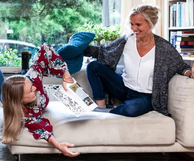 Verwarmd huis Twee vrouwen lachend op een bank