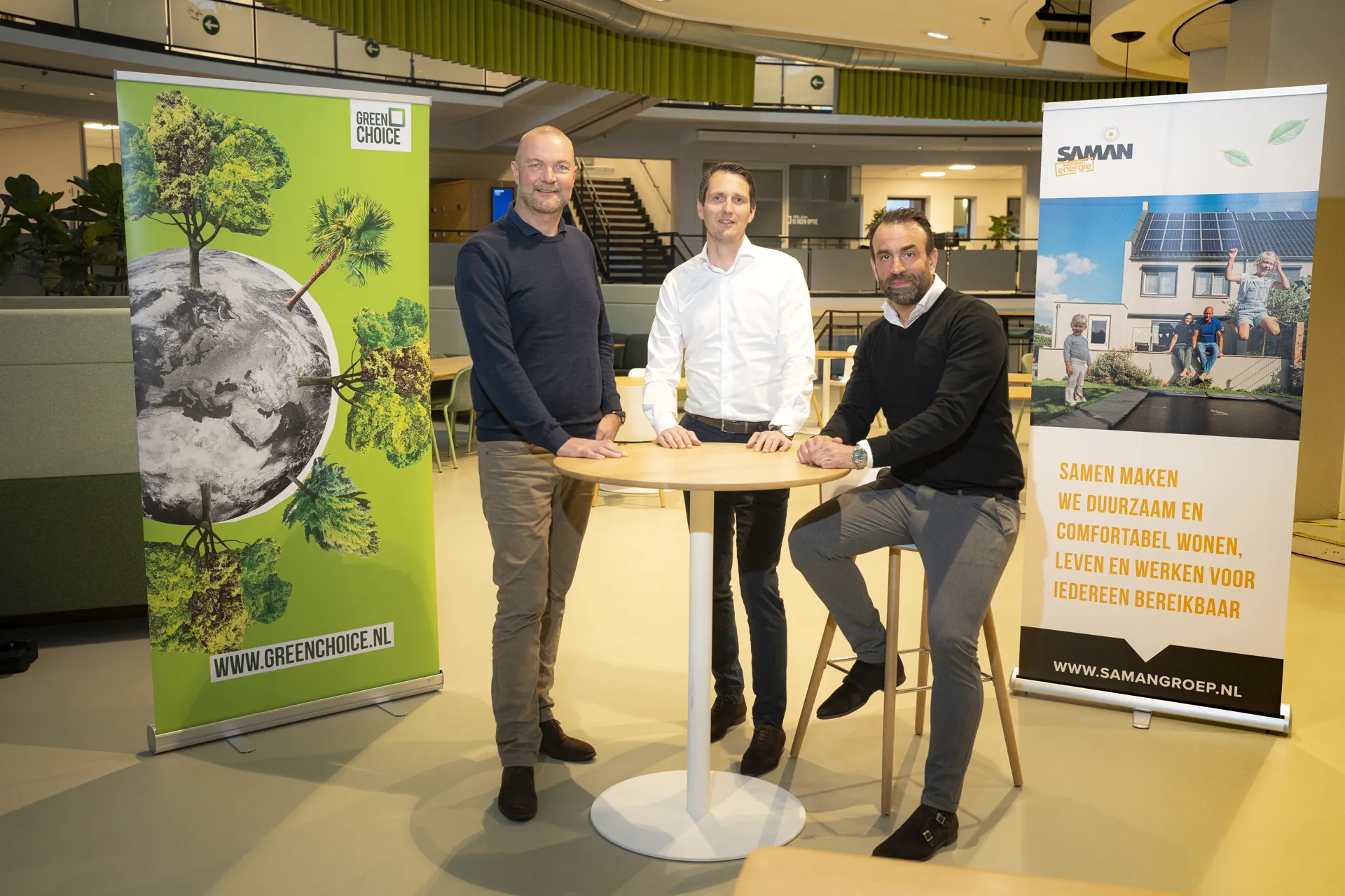 Daniël Lodders en Coen de Ruiter staan samen aan tafel om te vieren dat Saman Groep en Greenchoice een samenwerking aangaan.