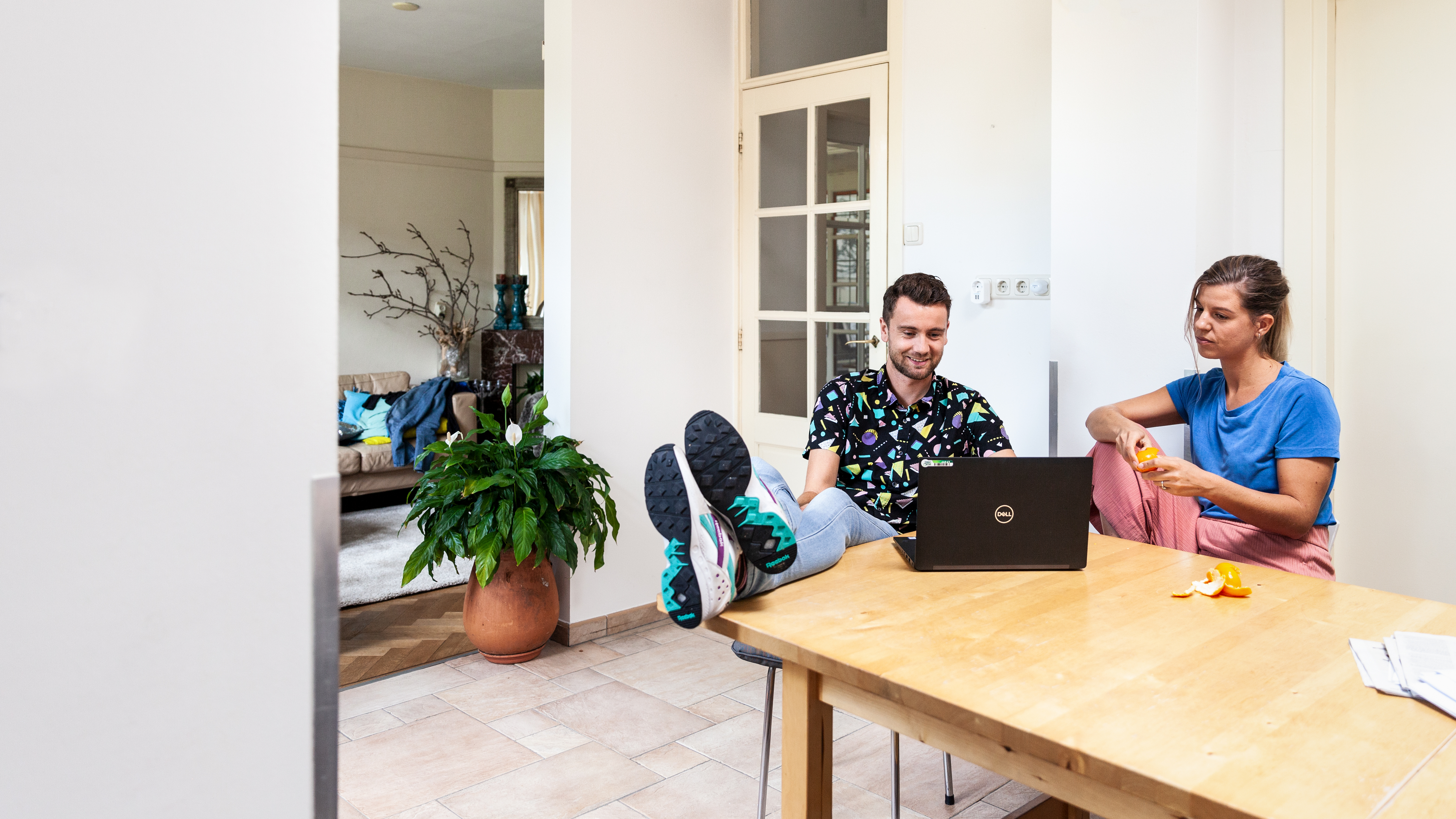 Twee mensen regelen zelf hun energiezaken, op de laptop aan de eettafel.