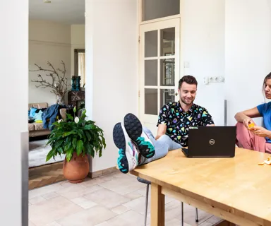 Energiezaken zelf regelen op laptop Twee mensen regelen zelf hun energiezaken, op de laptop aan de eettafel.